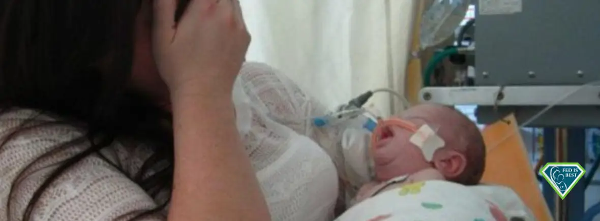 Grieving mother holds sick infant in NICU.