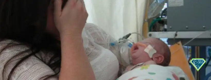 Grieving mother holds sick infant in NICU.