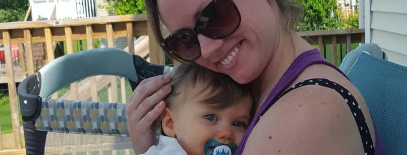 Woman cuddling baby on patio.