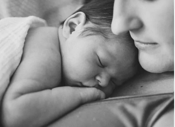 Newborn baby sleeping on mother's chest.