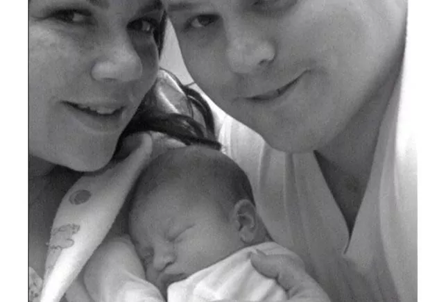 Happy parents holding their newborn baby.