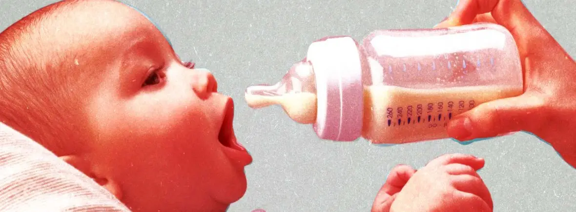 Baby drinking milk from bottle.