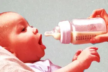 Baby drinking milk from bottle.