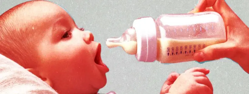 Baby drinking milk from bottle.