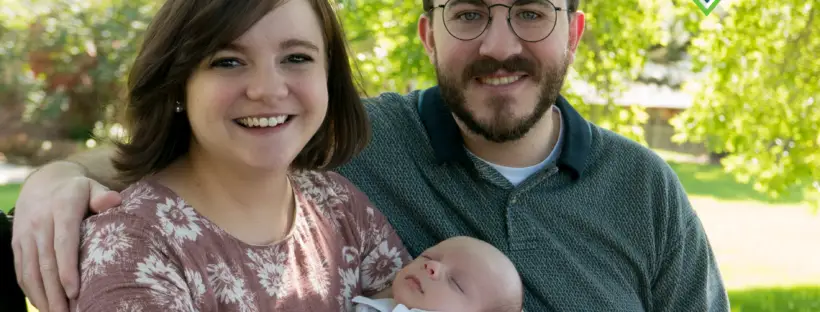 Happy family with newborn baby outdoors.