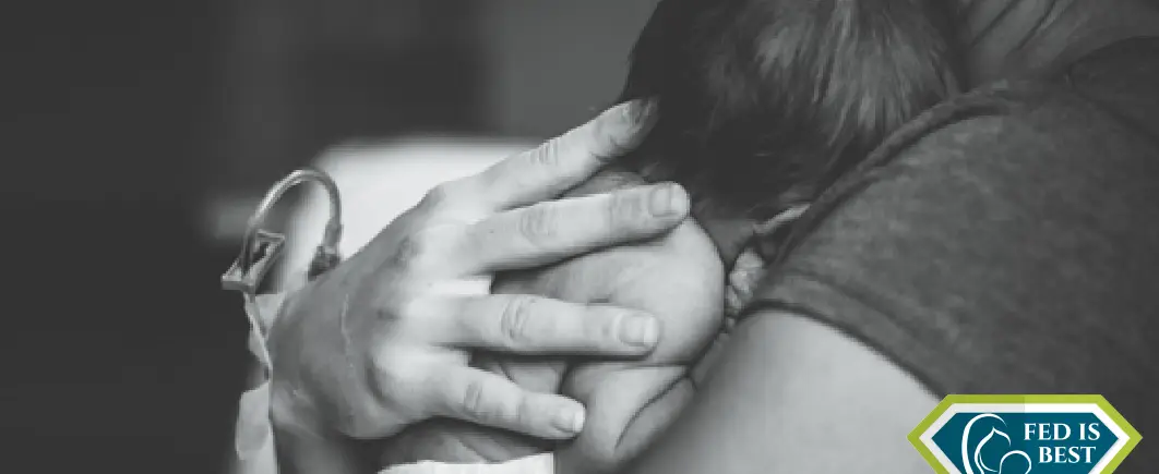 A black and white picture of a mom hugging her baby