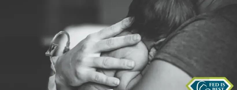 A black and white picture of a mom hugging her baby