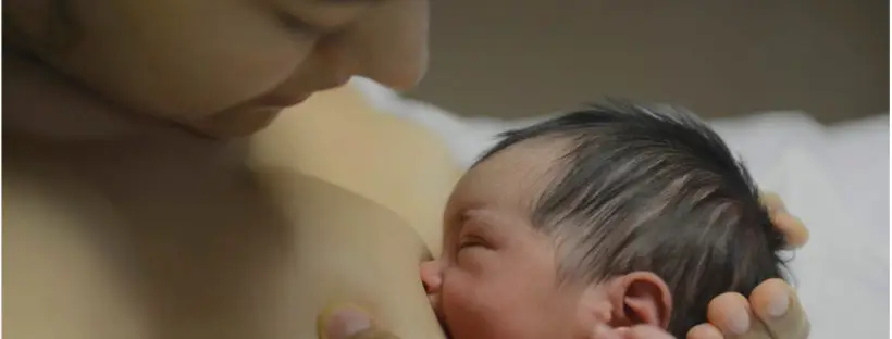 Mother breastfeeding newborn baby.