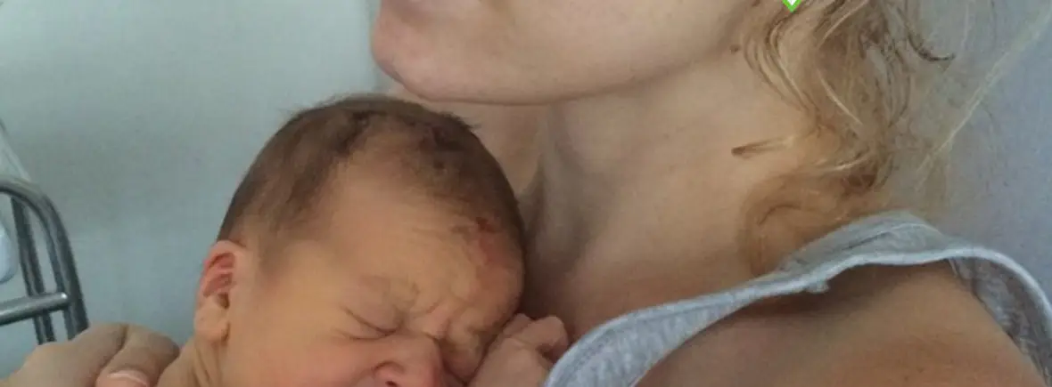 Mother holding and comforting crying newborn.