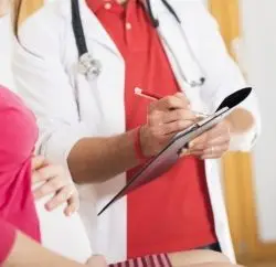 Here's an alt tag for the image: Doctor consulting pregnant patient.