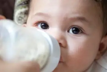 Baby drinking from a bottle.