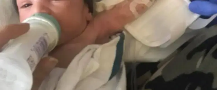 Newborn baby bottle-feeding in hospital.
