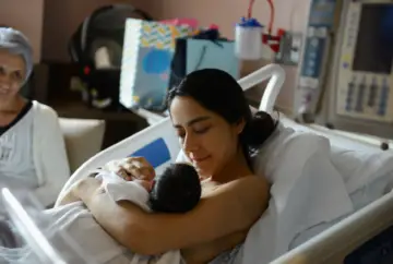 Mother lovingly holds her newborn baby.